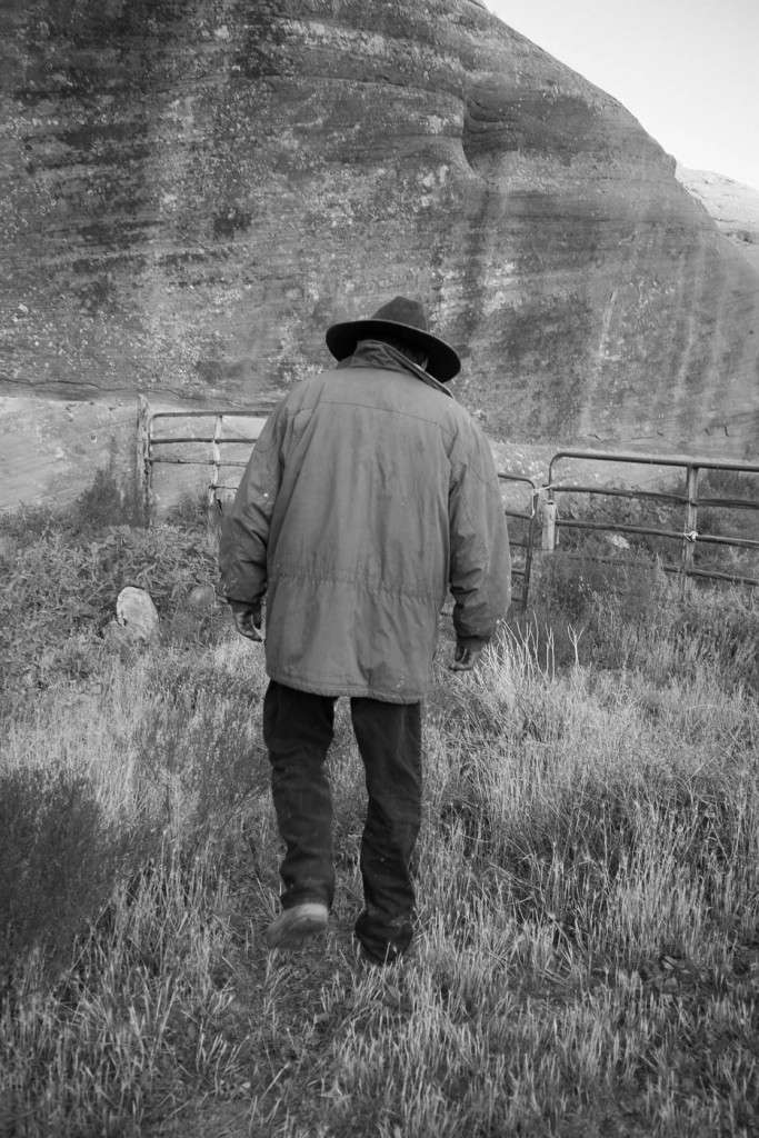 A Navajo guide attentding to horses inside Canyon de Chelly