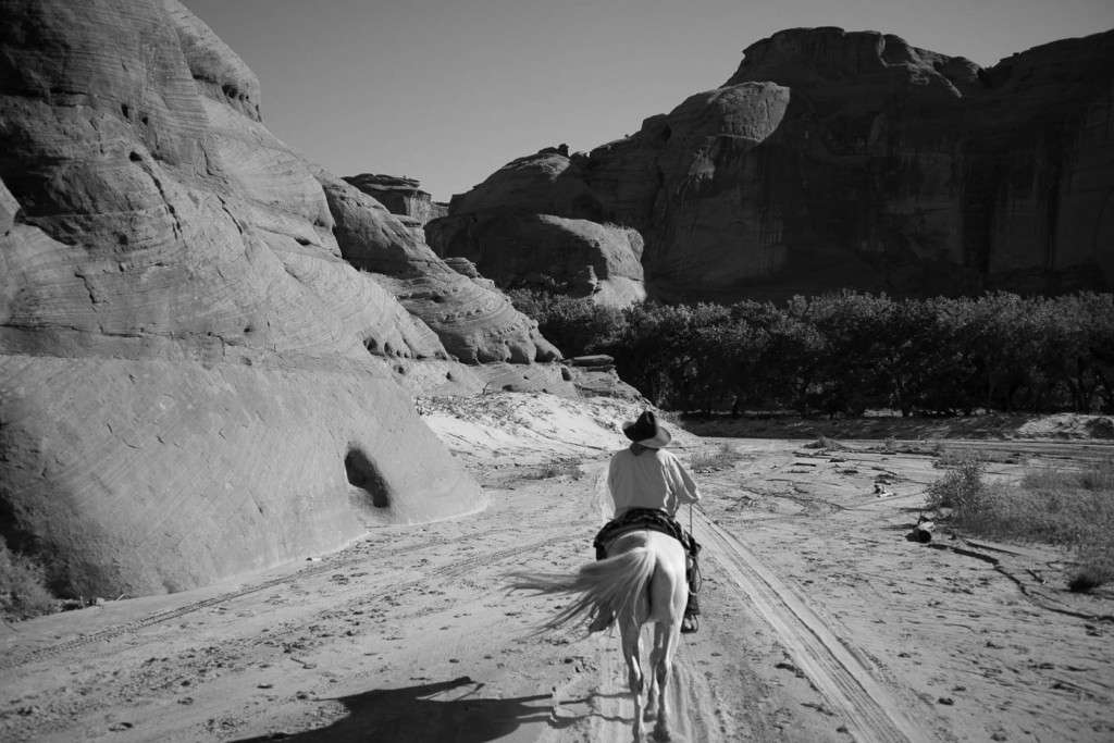 A Navajo guide on horse back on a photo tour inside Canyon de Chelly
